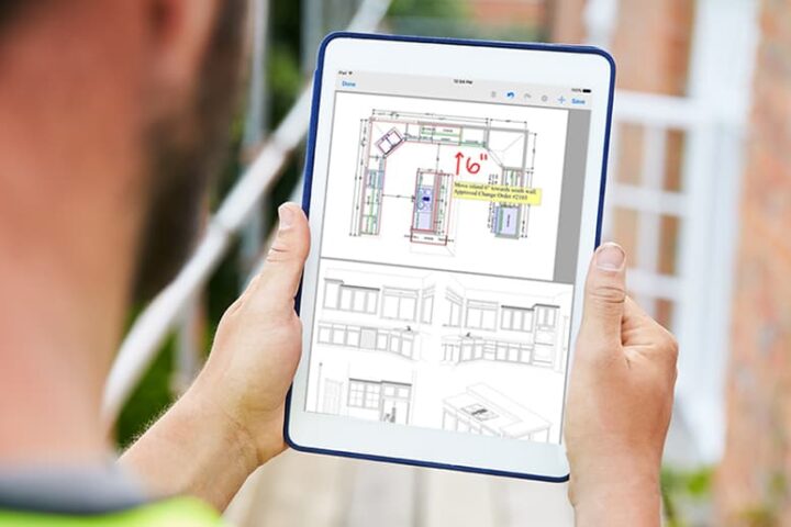 Construction worker looking at floor plans on tablet