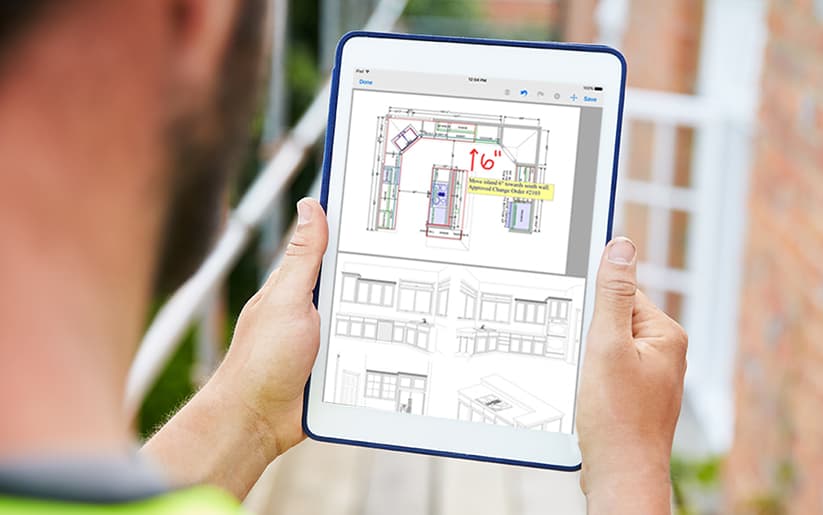 Construction worker looking at floor plans on tablet
