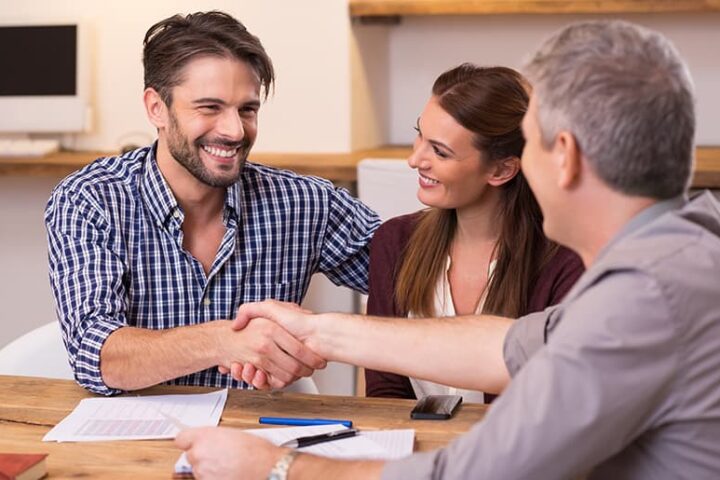 Couple shaking hands with a man