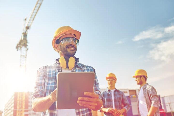 Construction workers on-site using a tablet