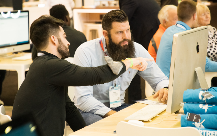 Buildertrend employee shows the construction software to a builder at a trade show.