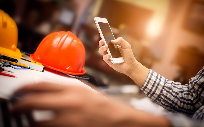 Construction worker scrolling through iphone.