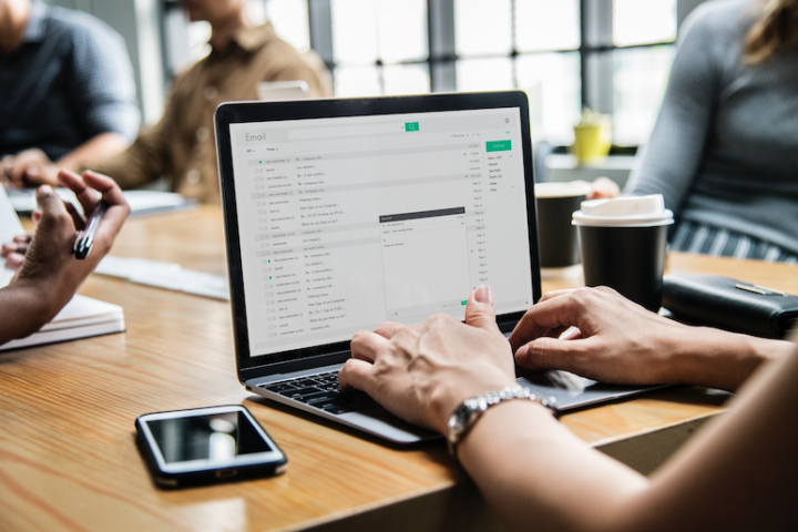 Woman typing email in business meeting.