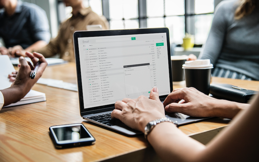 Woman typing email in business meeting.