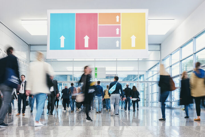Bustling hallway with arrow graphic hanging from the ceiling