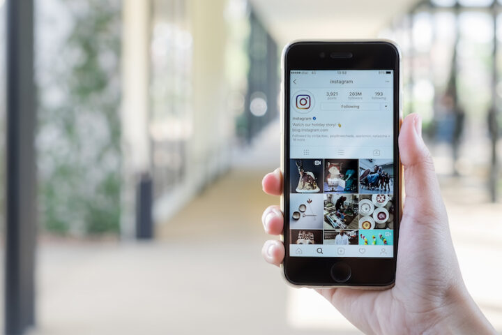 Closeup of a hand holding a mobile device with Instagram on the screen