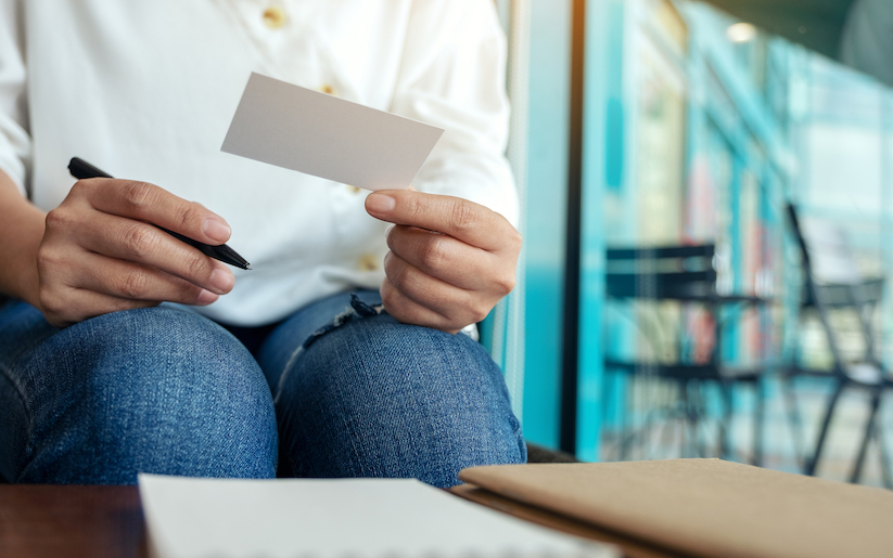 Person holding card taking notes.