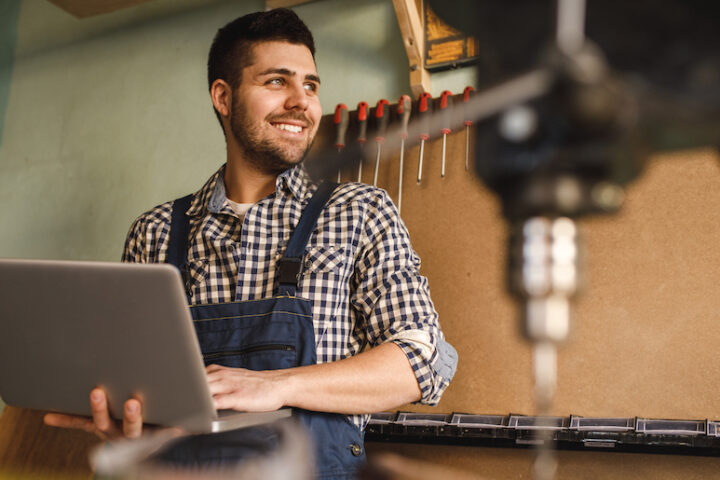 Person holding a laptop and smiling