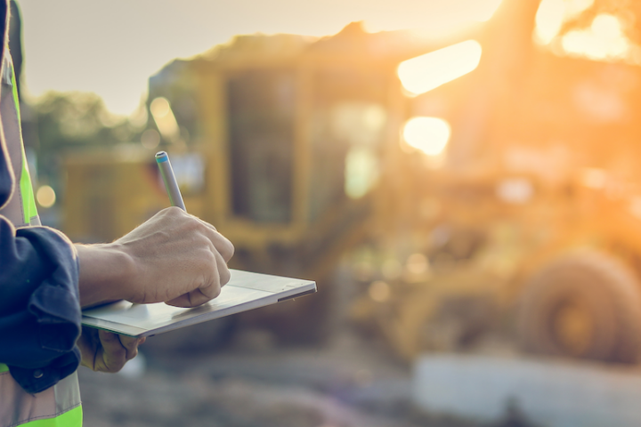 Photo of construction worker taking notes while on the job site