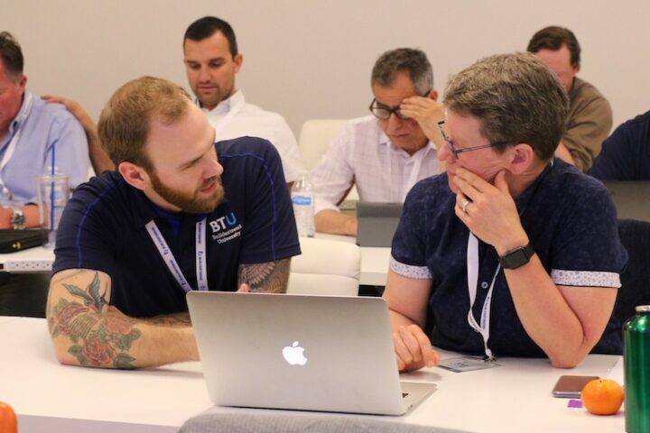 Two business men conversing in a classroom