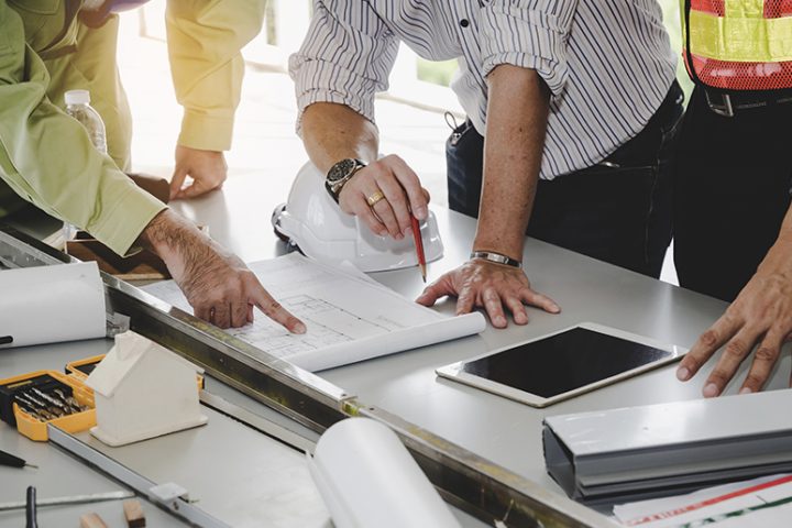 People working around a desk focusing on documents