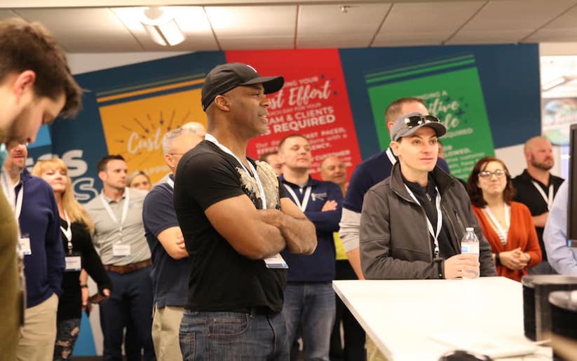 A small crowd of people in a room generally looking the same direction