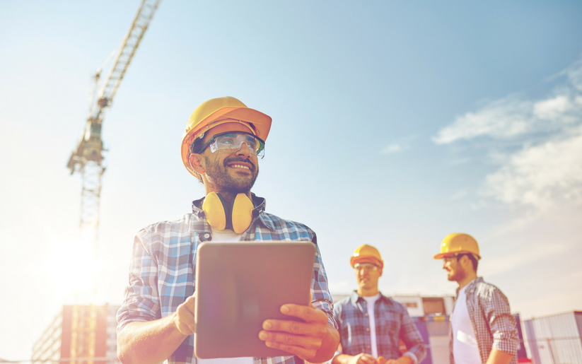 Construction workers on-site using a tablet