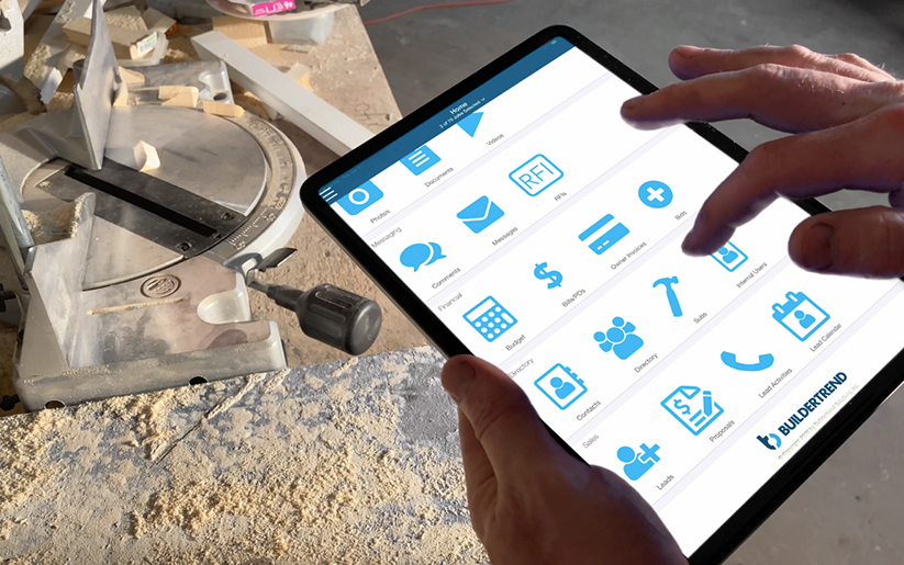 Buildertrend software on a tablet screen with power tools in the background