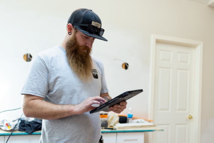 Construction worker holding tablet device.