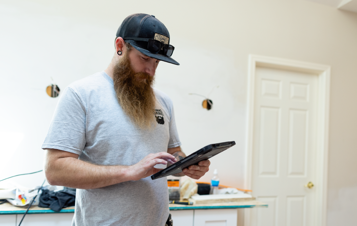 Construction worker holding tablet device.