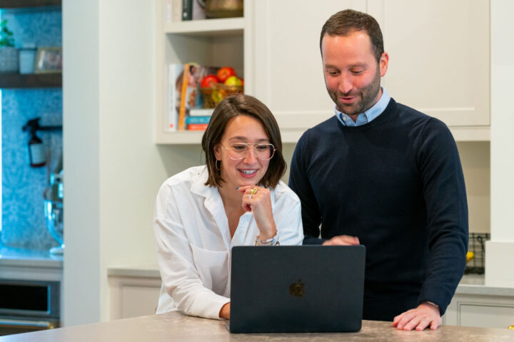 Two clients looking at laptop together.