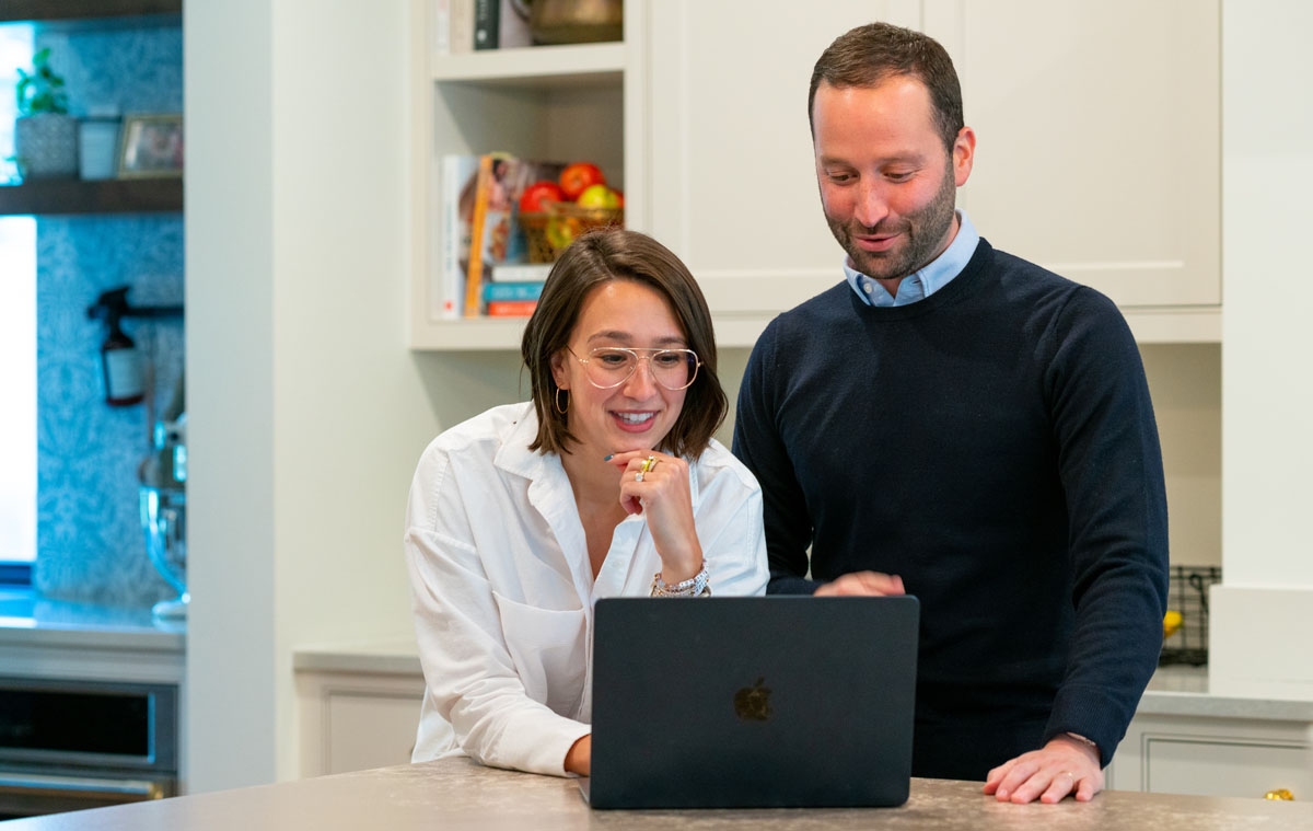 Two clients looking at laptop together.