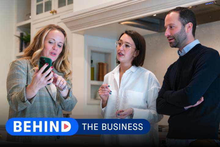 Katie Kath of Jkath Design Build + Reinvent shows home buyers a communication tool like Buildertrend on her phone