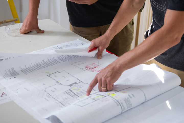 Construction workers looking over a blueprint.