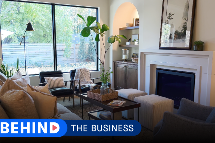 Living room in Tudor home, built by Jkath, with text that reads "Behind the Business."