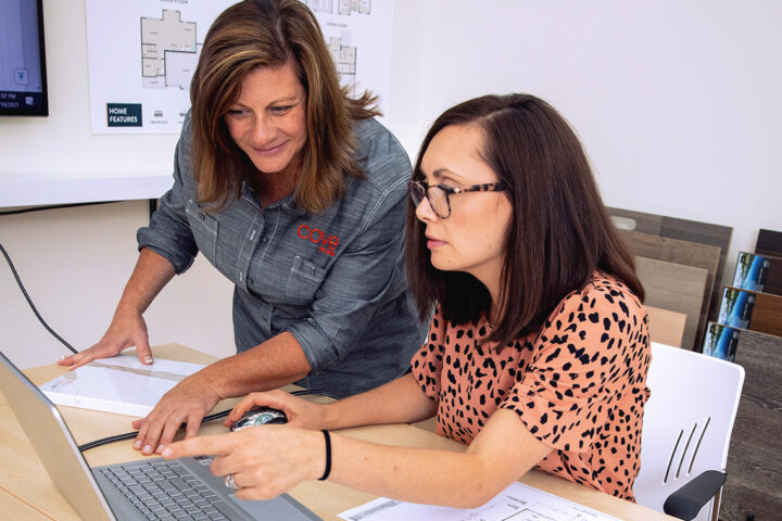 Two women work on taxes on their computer