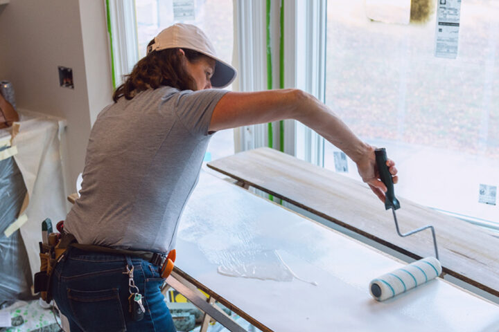 Construction worker painting a board.