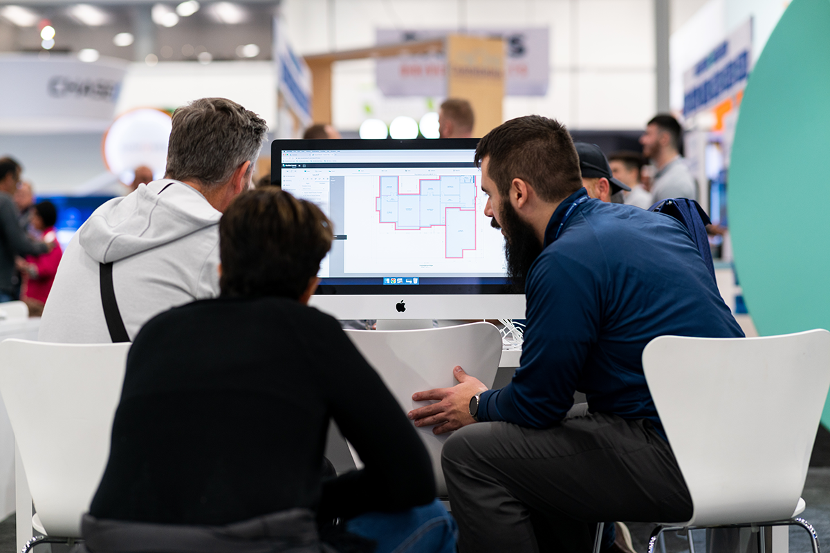 Group of people sitting around a computer looking at a floorplan