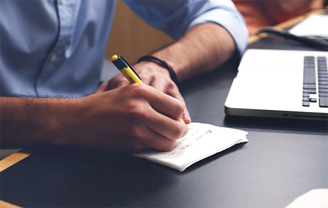 A person write on paper with a pen