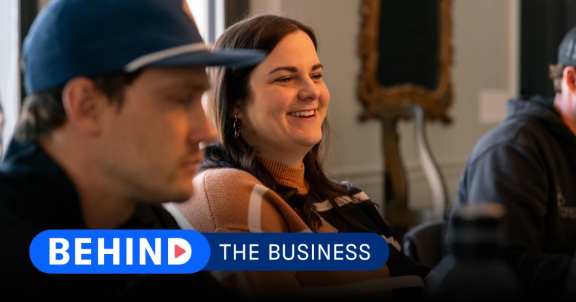 Kayla from construction2style working with her construction team and a graphic of "Behind the Business" displayed at the bottom.