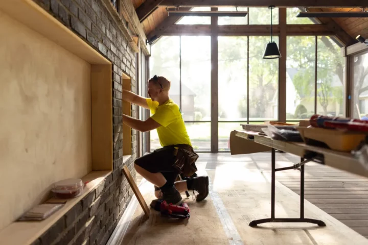 A construction worker using a level on a wall