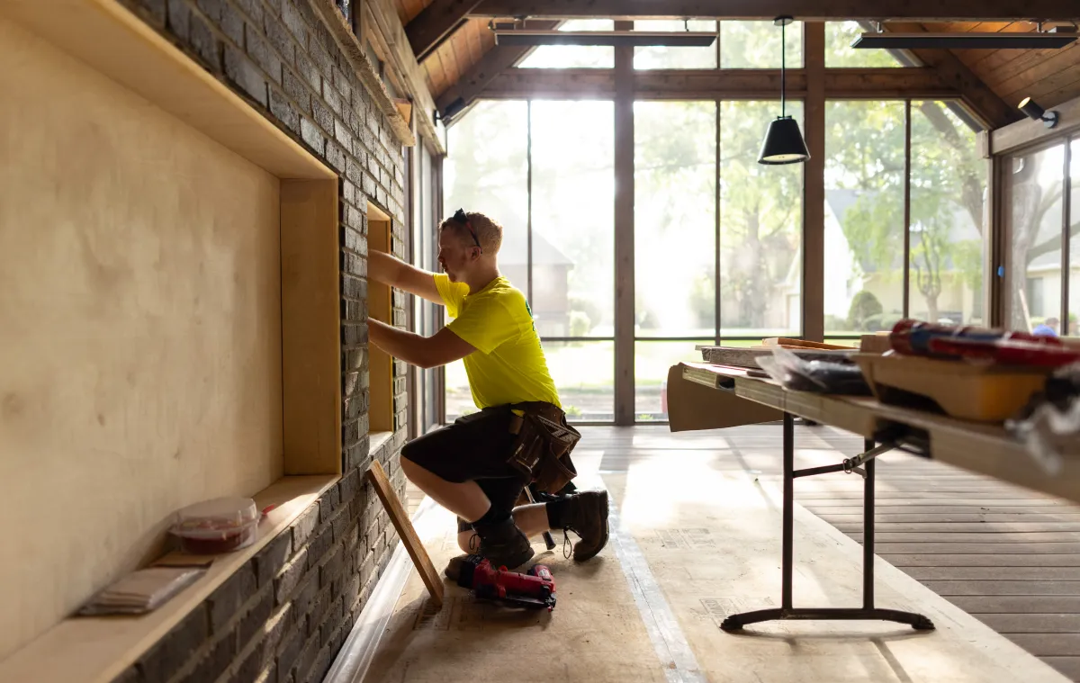 A construction worker using a level on a wall