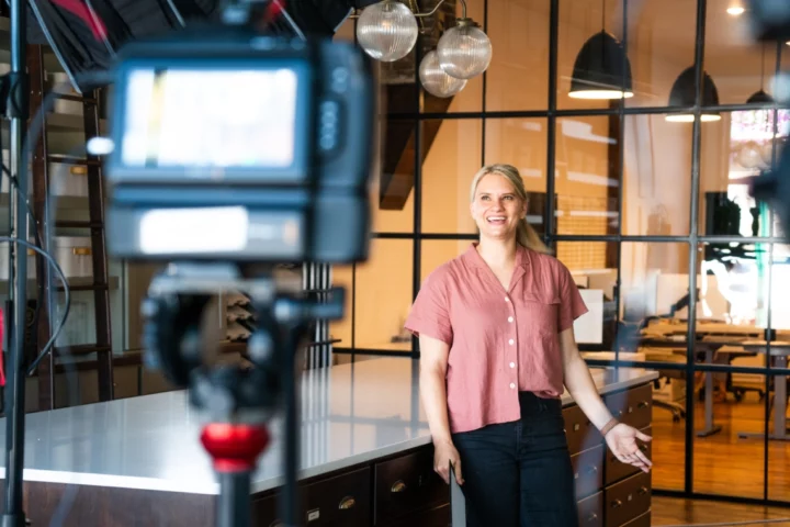 A woman builder standing in a new home build standing in from of a camera being filmed