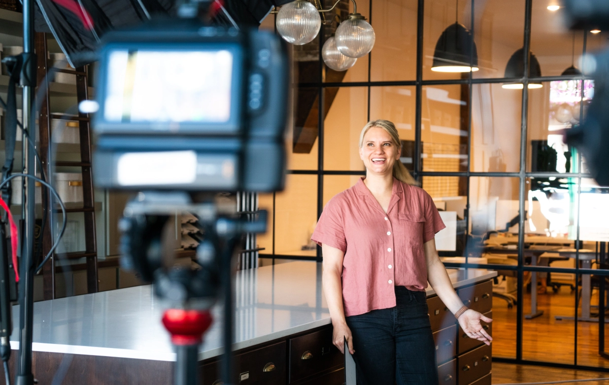 A woman builder standing in a new home build standing in from of a camera being filmed