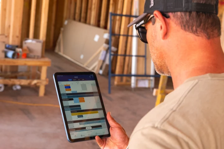 A man looking at an ipad with a construction schedule showing