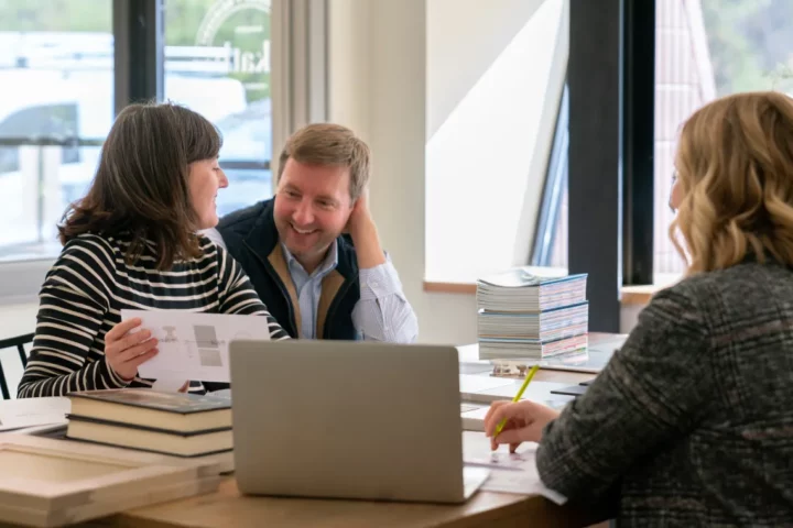 Three people sitting around a table looking at sample selections
