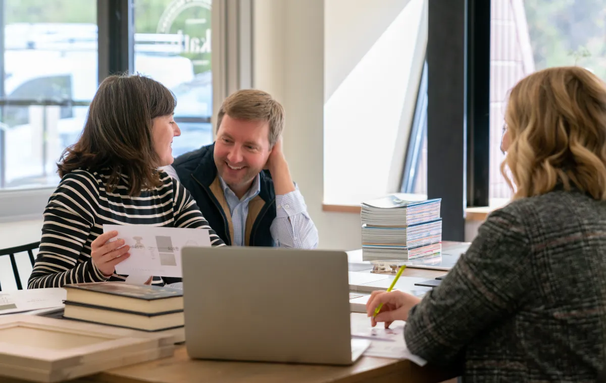 Three people sitting around a table looking at sample selections