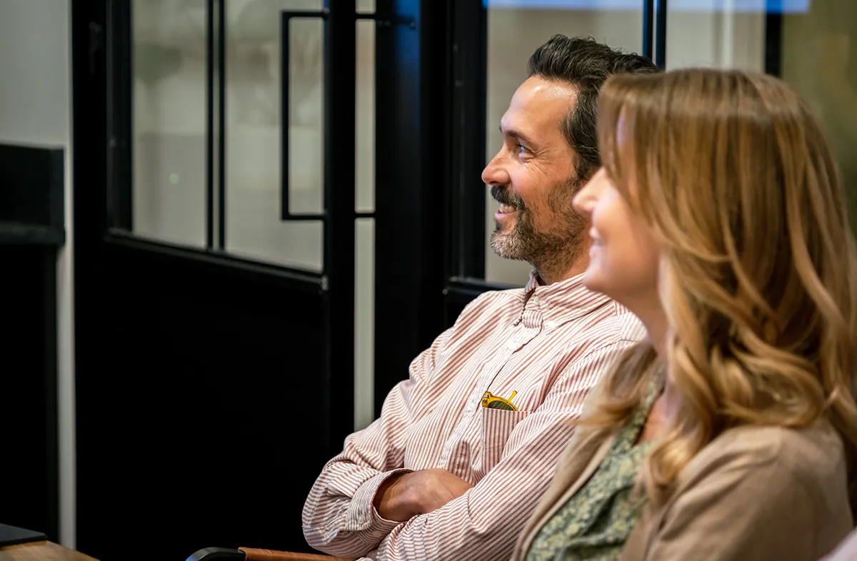 Man and woman sitting listening to someone out of photo speak