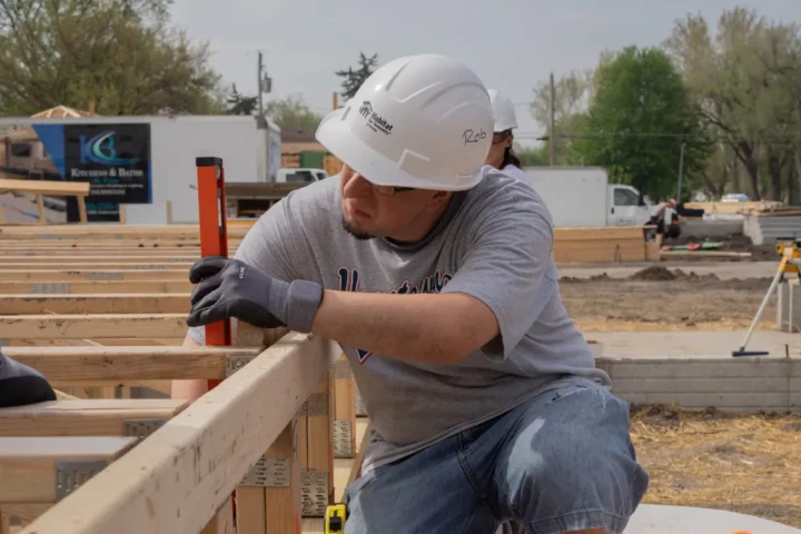 Person in a hard hat working on the foundation of a house