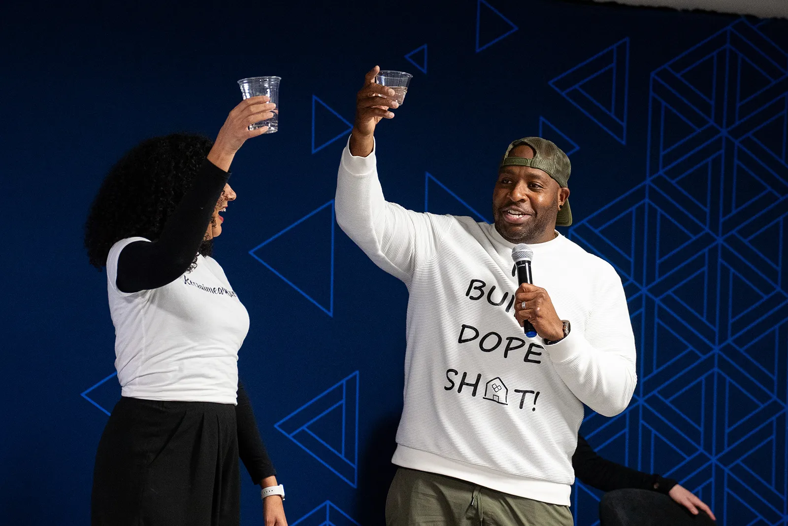 Man and woman toasting each other on stage