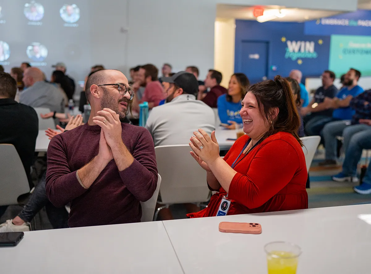 Man and woman sitting next to each other at table enjoying conversation