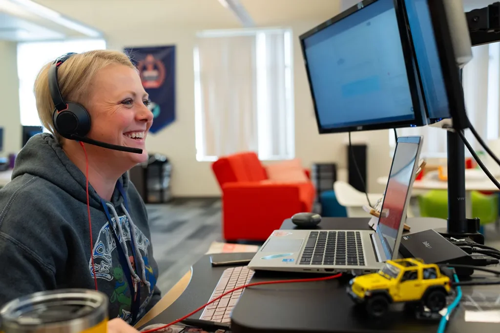 CS rep sitting at desk chatting with head set