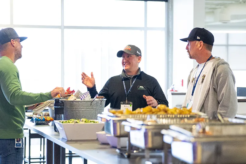 three people chatting over buffet line
