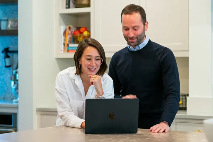 Two builders looking at a laptop screen together