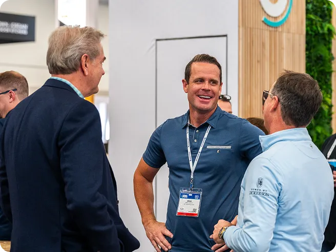 Three men speaking to each other at IBS