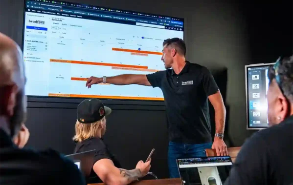 Bradford Custom Homes team looking at a Buildertrend screen during a team meeting