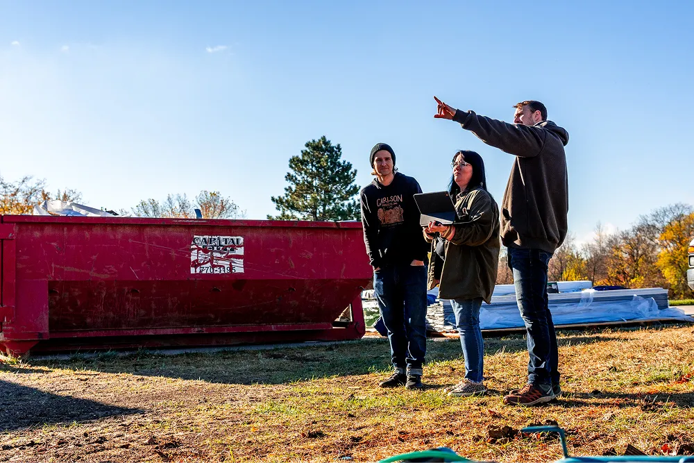 Three team members looking at a construction site