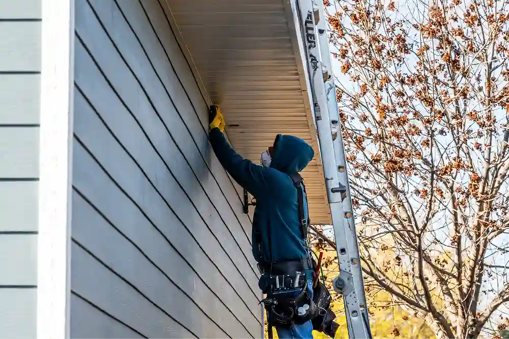 Team member working on home siding