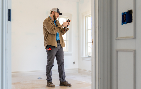 Team member from CopeGrand Homes at a construction site taking notes
