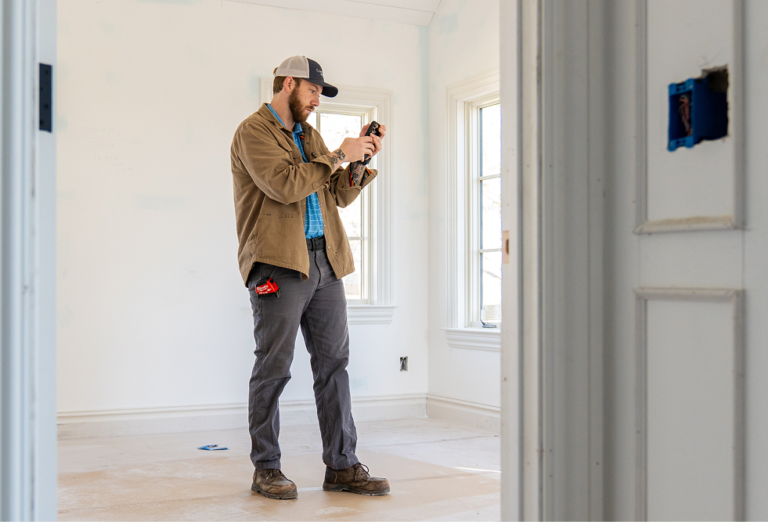 Team member from CopeGrand Homes at a construction site taking notes